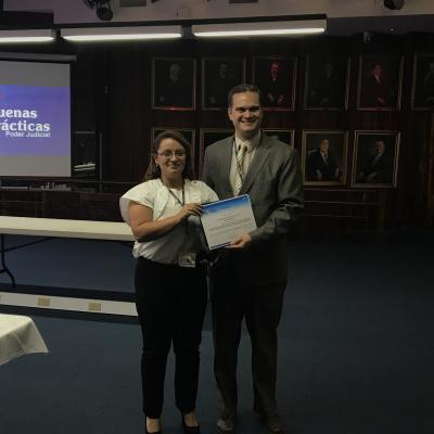 hombre y mujer posando y mostrando un certificado 