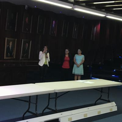 tres personas de pie exponiendo