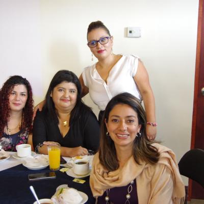 cuatro mujeres sentadas se posan para foto