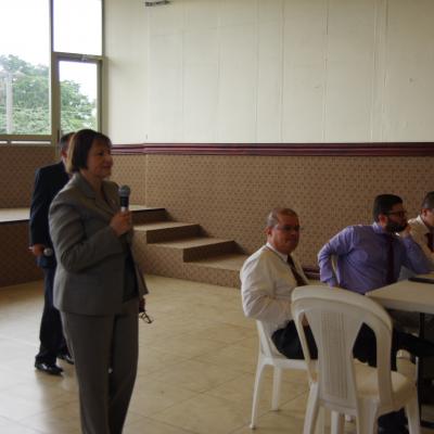 mujer de pie expone con micrófono en mano 