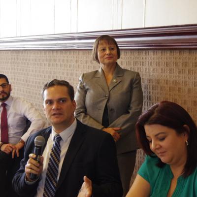 hombre ejecutivo sentado habla con micrófono en mano 