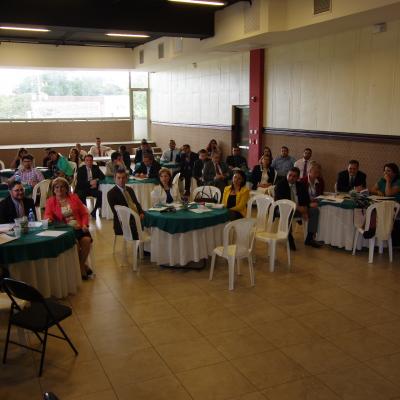 grupo de personas en el evento sentados alrededor de las mesas redondas 