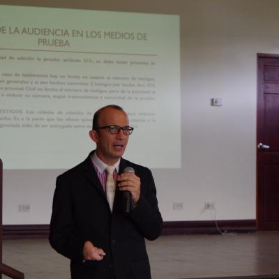 hombre de pie habla con micrófono en mano