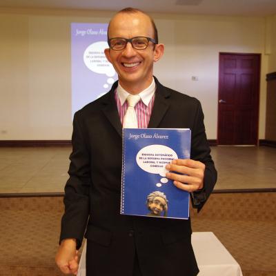hombre sonriente posa para la foto con libro en sus manos 