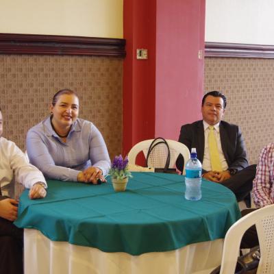 tres personas sentadas en mesa redonda 