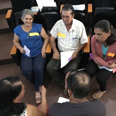 Hombres y mujeres discutiendo y conversando tema específico en grupo
