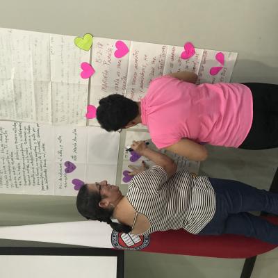 Mujeres escribiendo en papeles pegados en la pared