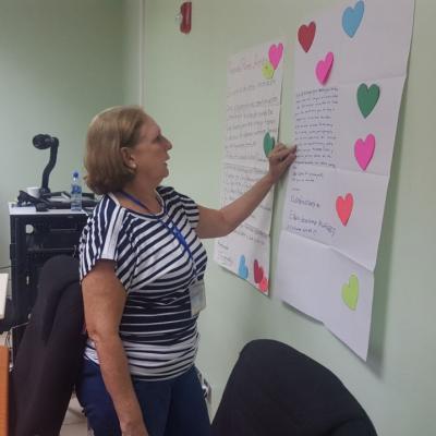 Mujer facilitadora participando y leyendo cartel en actividad