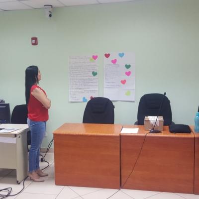 Mujer facilitadora leyendo carteles en la pared creados en actividad 