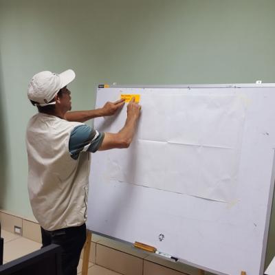 Hombre colocando su idea en la pizarra en actividad de facilitadores