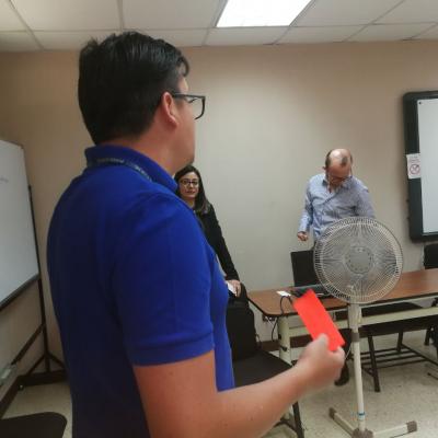 Hombre con tarjeta roja en la mano presentando información a compañeros