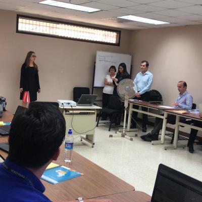 Mujer presentando información a grupo de personas