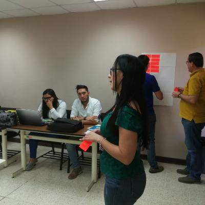 Mujer presentando información a compañeros