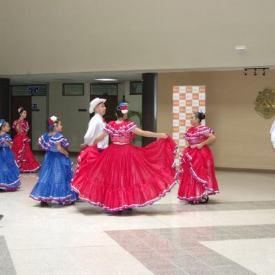 Niños bailando con trajes típicos azul y rojo