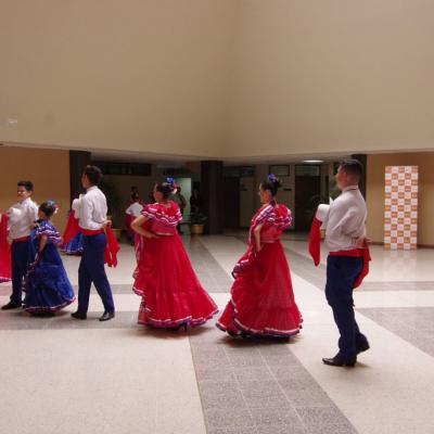 Niños bailando típico, con trajes azul, blanco y rojo
