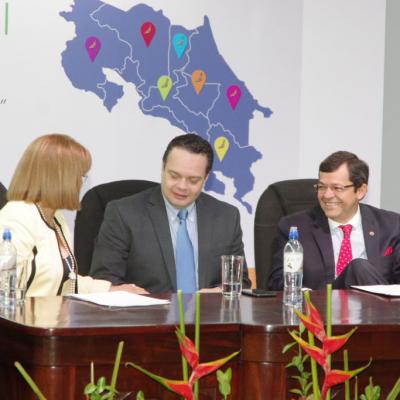 dos hombres ejecutivos sentados y mujer de blanco