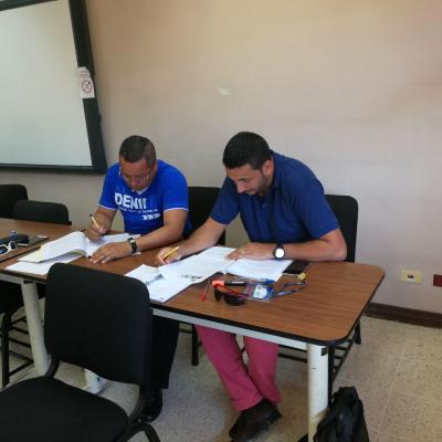 Dos hombres anotando y leyendo en un escritorio