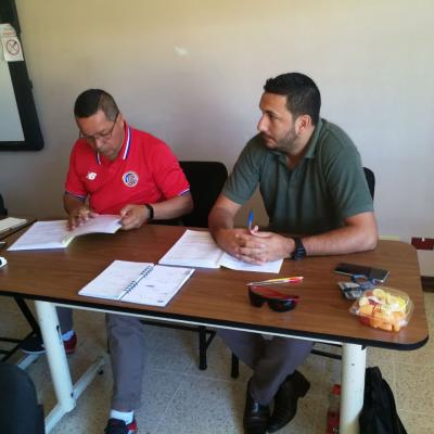 Dos hombres sentados en un escritorio leyendo