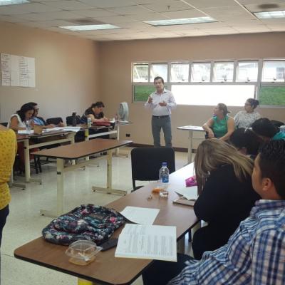 Grupo de personas sentados disfrutando de actividad mientras hombre presenta