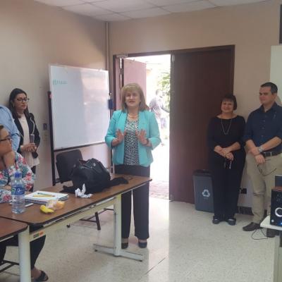 Grupo de personas sentados disfrutando de actividad mientras mujer presenta
