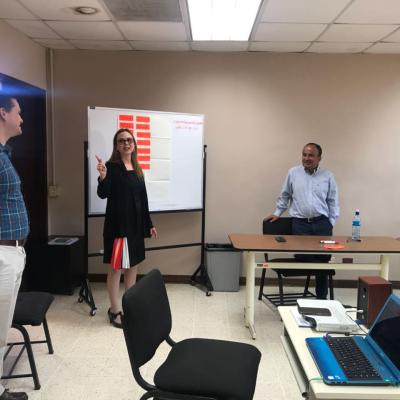 Mujer presentando información a sus compañeros