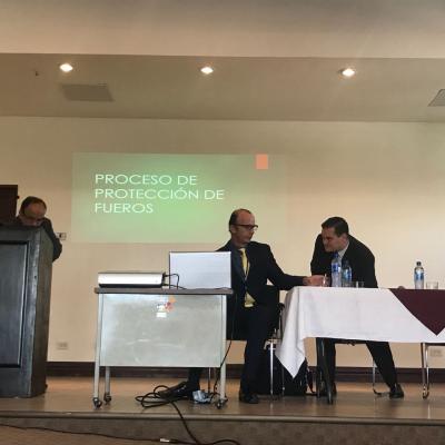 Tres hombres presentando información sobre Proceso de protección de fueros