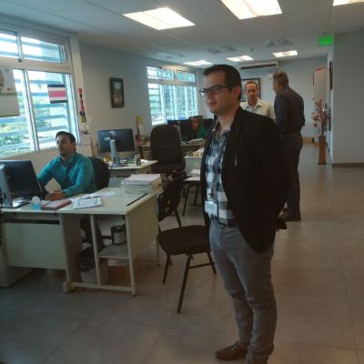 Hombre de pie en la oficina, detrás escritorios y compañeros