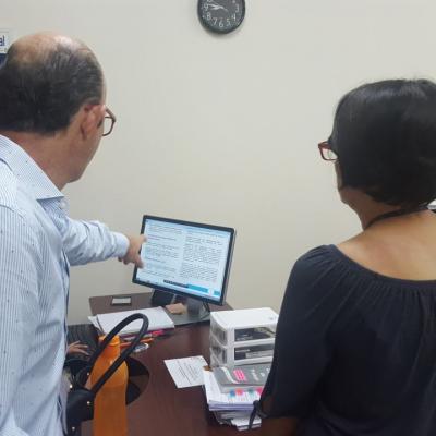 Hombre señalando información de la computadora a mujer