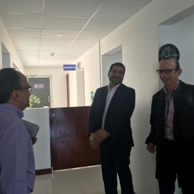 Tres hombres de pie hablando entre ellos