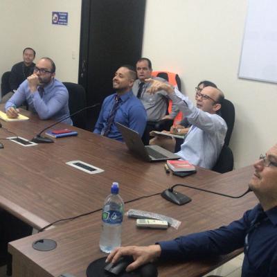Grupo de hombres sentados viendo y señalando a la pantalla