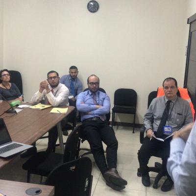 Grupo de personas sentadas viendo a su compañero presentar