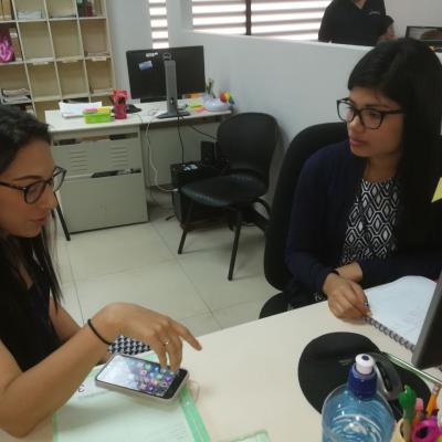 Dos mujeres sentadas en una mesa hablando