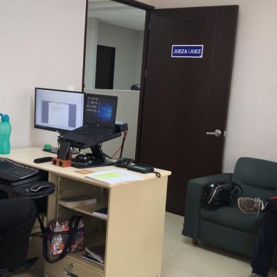 Oficina de jueza/juez con tres personas hablando
