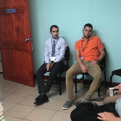 Cinco hombres sentados en una reunión de trabajo