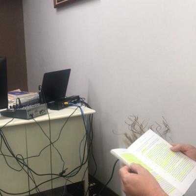 Un hombre sentado en su escritorio y otro leyendo un libro