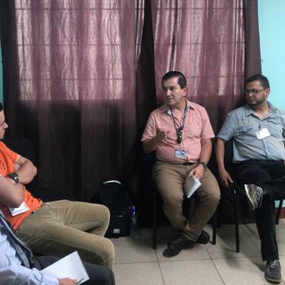 Cuatro hombres sentados dialogando