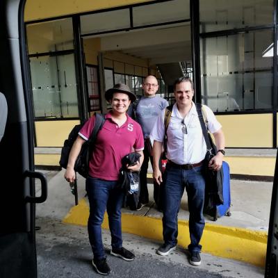 Tres hombres de pie sonriendo