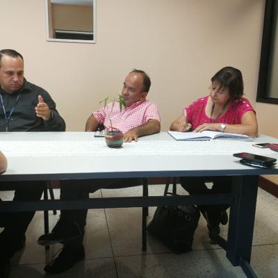Dos hombres y una mujer discutiendo en una reunión 
