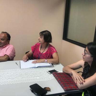 Tres personas sentadas en una reunión