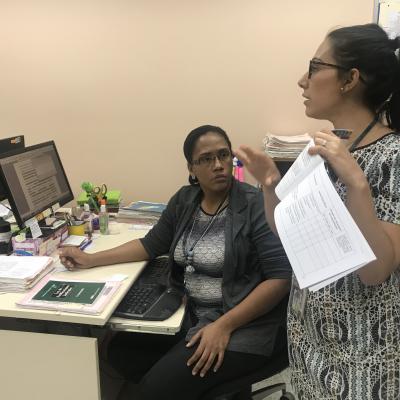 Mujer de pie explicando a sus compañeros de trabajo