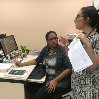 Mujer de pie explicando a sus compañeros de trabajo