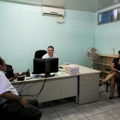 Dos hombres y una mujer hablando en oficina