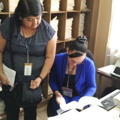 Dos mujeres leyendo y discutiendo folleto en su escritorio