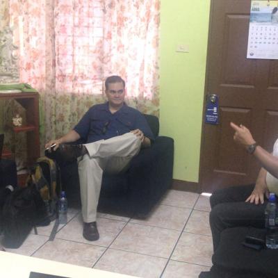 Dos hombres y una mujer sentados en sala hablando