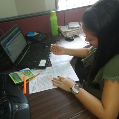 Mujer sentada en su escritorio revisando documentos