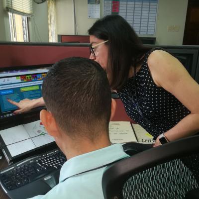 Mujer discutiendo información con compañero en su computadora
