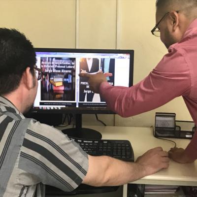 Dos hombres revisando información en computadora