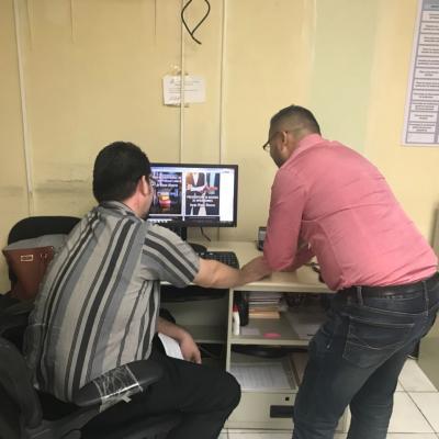 Dos hombres conversando sobre información en computadora