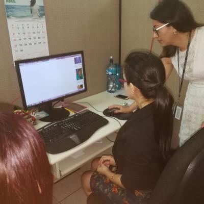 Tres mujeres en escritorio revisando información de computadora