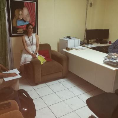Mujer sentada en sillón presentando a compañeros